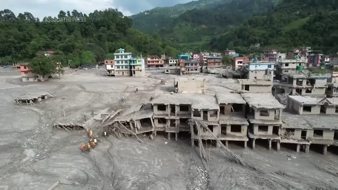 Damaged buildings and flood sediment in Nepal. Still from the supplied Associated Press video; recording date not provided.